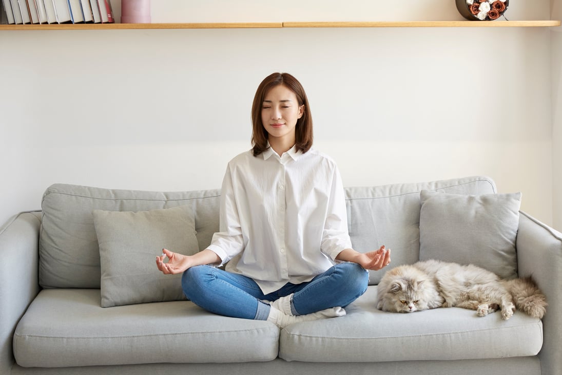 young asian woman meditating at home